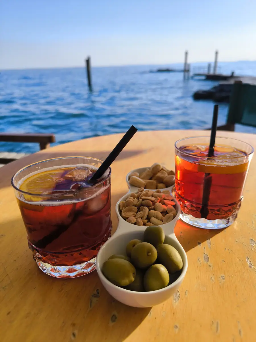 Two sunset drinks on a table at Punta San Vigilio with Lake Garda in the background