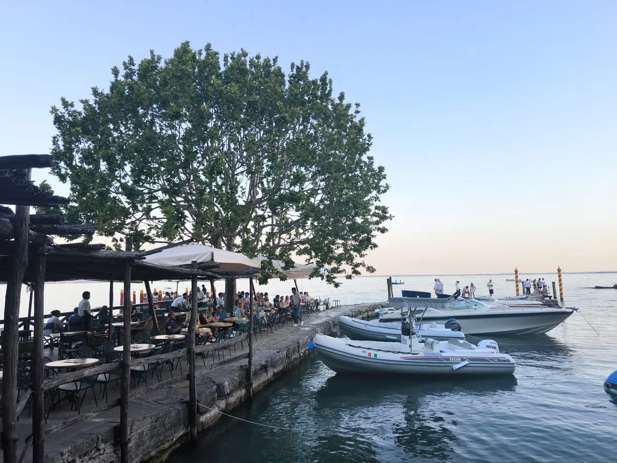 Punta San Vigilio terrace with boats beside Lake Garda