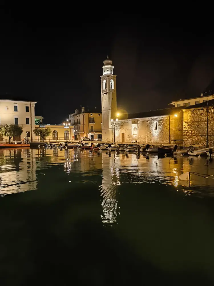 Lazise harbour and lakeside buildings reflected at night
